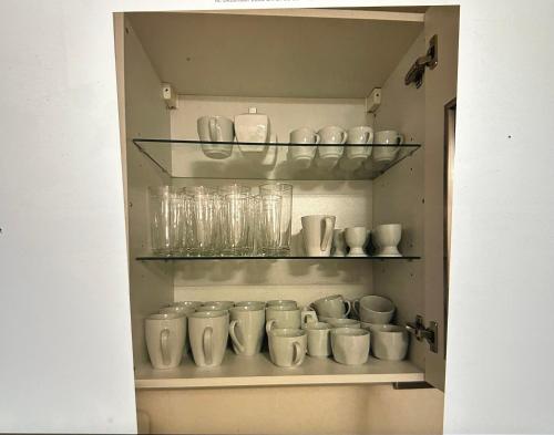 ein Schrank voller Tassen und Gläser in der Unterkunft Wunderschönes Haus mit Garten für 10 Personen in Hannover