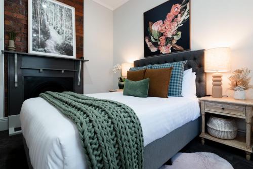 ein Schlafzimmer mit einem Bett mit einer grünen Decke darauf in der Unterkunft Bluebell Cottage in Invermay