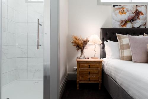 a bedroom with a bed and a shower at Bluebell Cottage in Invermay