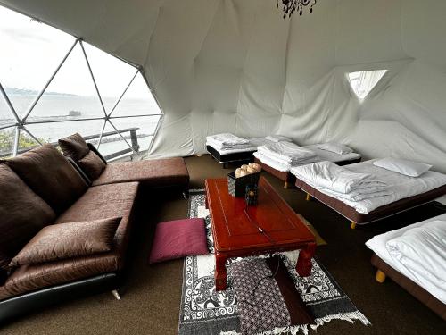 a living room with a couch and a table in a tent at Yamamizuki in Shimanto