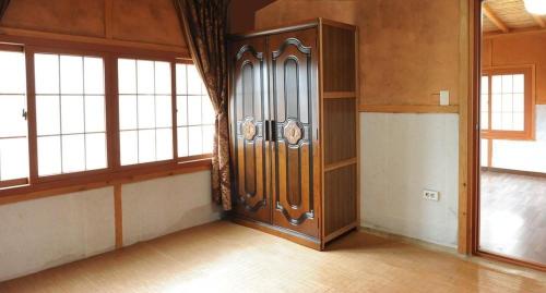 SancheongにあるJiri Mt Hwangto 지리산 황토の窓付きの客室内の大きな木製ドア
