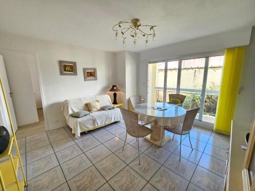 un salon avec une table et un canapé dans l'établissement Appartement Centre-Ville Calme avec Balcon et Garage - Saint-Georges-de-Didonne - FR-1-550-73, à Saint-Georges-de-Didonne