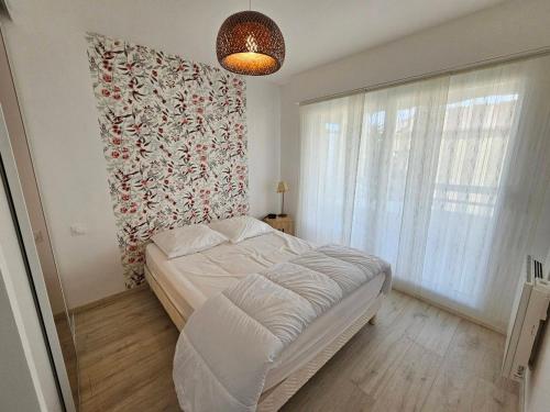 une chambre avec un lit et une grande fenêtre dans l'établissement Appartement Centre-Ville Calme avec Balcon et Garage - Saint-Georges-de-Didonne - FR-1-550-73, à Saint-Georges-de-Didonne