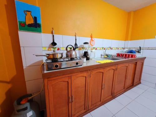 uma cozinha com um fogão e um lavatório em Amplio Departamento Amoblado de Estreno em Cajamarca