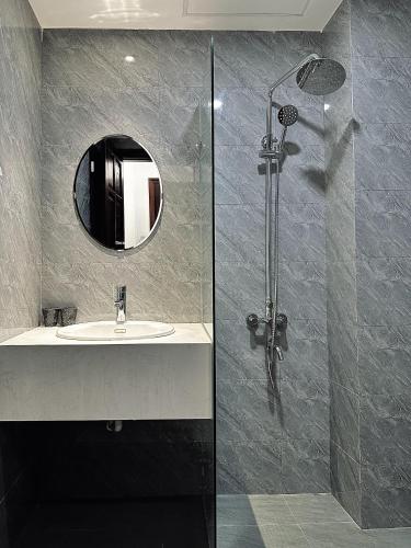 a bathroom with a sink and a shower at Han Riverine Hotel & Cafeteria DaNang in Danang