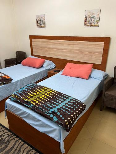a room with two beds and a chair in it at La sirena double room with mountain view, Families and couples only, Extra of 180 Egyptian pounds per adult person per stay ,to be paid to the resort in Ain Sokhna