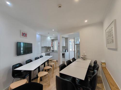 a meeting room with tables and chairs and a tv at Lisbon Terrace Suites Special for Groups up to 19 guests in Lisbon