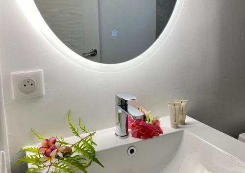 bagno bianco con lavandino e specchio di Mareta Lodge - studio RUA 2 a Bora Bora