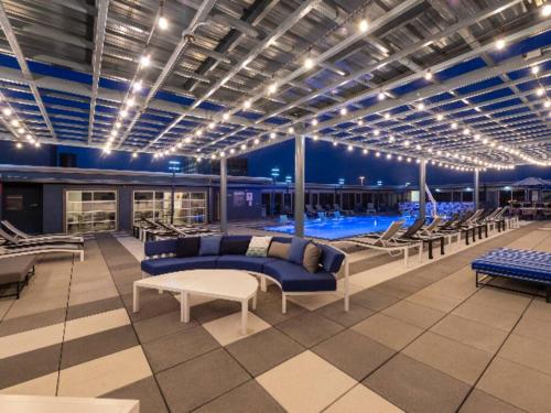 a pool room with a blue couch and chairs at Elite Retreat in Addison Circle in Addison