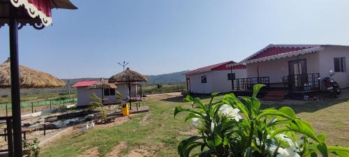 a group of buildings with grass roofs at Gitanjali Forest Retreat in Bāghmundi