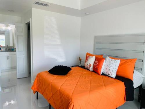 a bedroom with an orange bed with orange pillows at White house 1 in Lehigh Acres