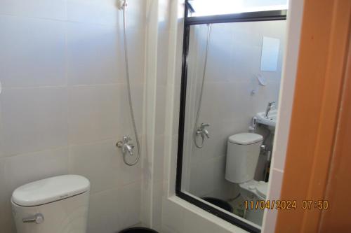 La salle de bains est pourvue d'une douche, de toilettes et d'un lavabo. dans l'établissement Leo Green Apartelle, à Jagna