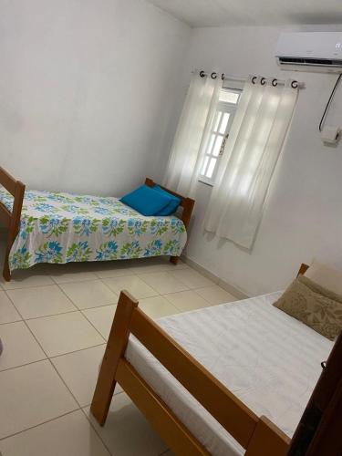 um quarto com duas camas e uma janela em Residencial Sauaçhuy em Ipioca