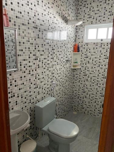 a bathroom with a white toilet and a sink at Residencial Sauaçhuy in Ipioca
