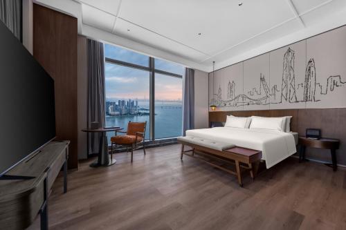a bedroom with a bed and a large window at Shenzhen Shekou Prince Bay Yifei Hotel in Shenzhen