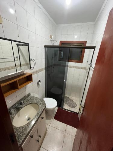a bathroom with a shower and a sink and a toilet at Apto 2D Capão da Canoa/Praça Flávio 150m Mar in Capão da Canoa