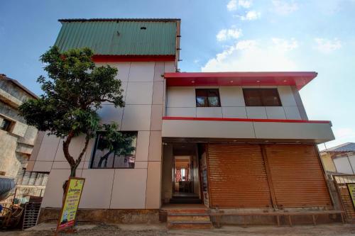 a building with a tree in front of it at SPOT ON Shreekrupa in Mahabaleshwar
