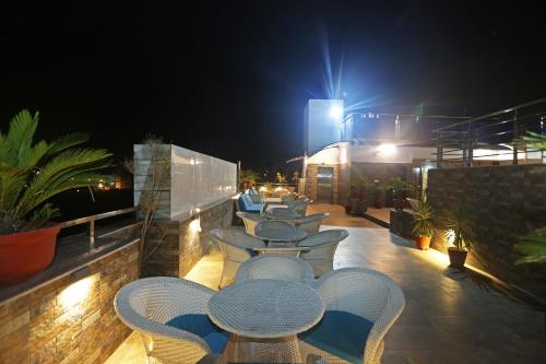 a row of tables and chairs on a balcony at night at Collection O Pearl Blue in Tājganj