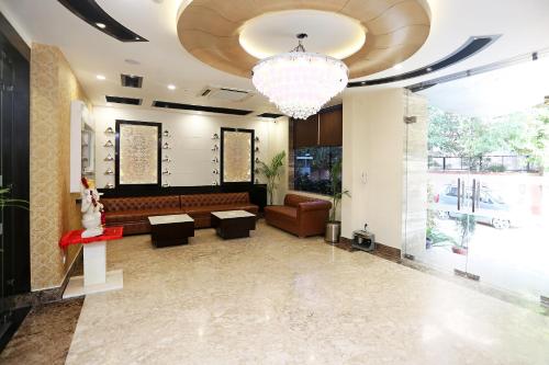 a living room with a couch and a chandelier at Collection O Hotel Pearl Blue in Tājganj