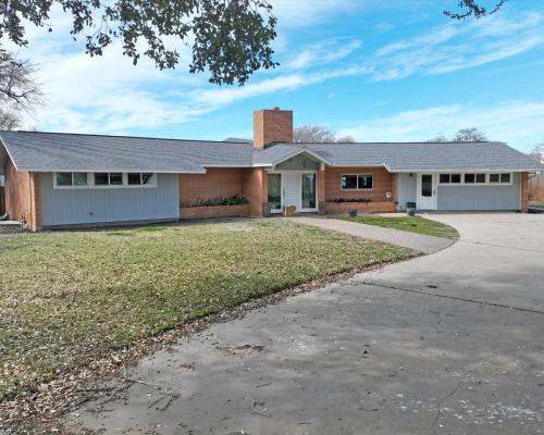 a home in a subdivision with a driveway at Whispering Breezes at Windy Hill in Corpus Christi