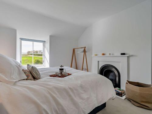 a white bedroom with a bed with a fireplace at 3 Bed in Malton 94171 