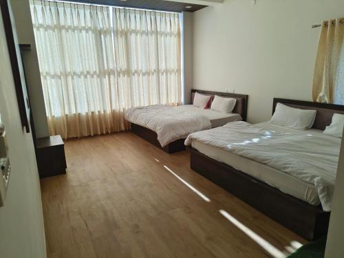 two beds sitting in a room with a window at Hotel ananya fairview in Khātu