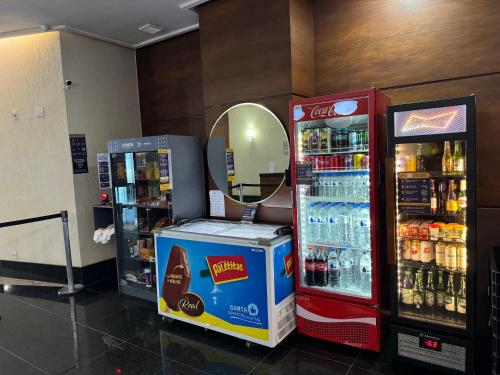 duas máquinas de refrigerantes e um espelho numa loja em Loft em frente à Praia em Vitória