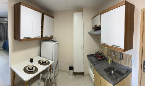 uma pequena cozinha com um lavatório e um frigorífico em Loft em frente à Praia em Vitória