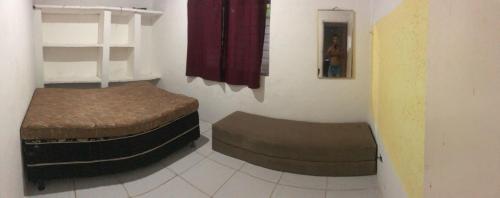 ein Zimmer mit zwei Ottomanen und einem Bett darin in der Unterkunft Casa de praia com 3 quartos, 2 banheiros, mobiliada e com piscina em enseada dos corais a 200m da praia in Cabo de Santo Agostinho