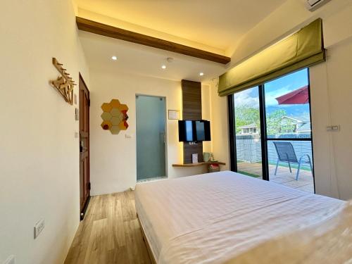 a bedroom with a large bed and a balcony at Hualien Wazuka Homestay in Hualien City