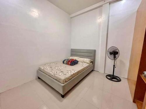 a white room with a bed and a fan at Baguio transient house in Baguio
