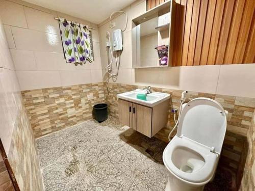 a bathroom with a toilet and a sink at Baguio transient house in Baguio