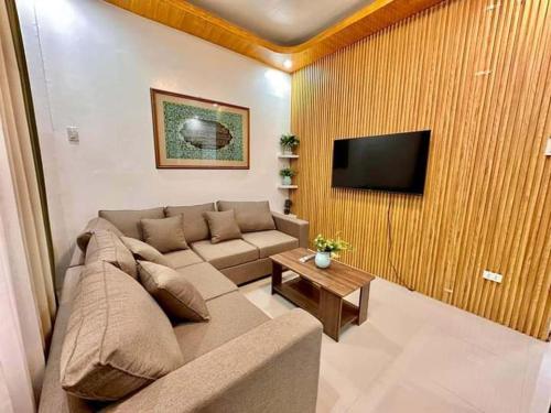 a living room with a couch and a flat screen tv at Baguio transient house in Baguio