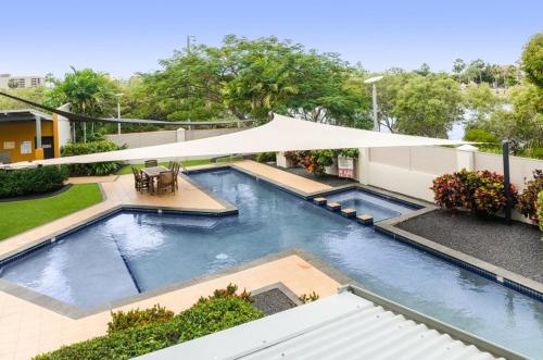 a large swimming pool with a white umbrella at City Riverside Apartment 25 in Townsville