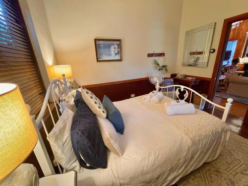 een slaapkamer met een bed met kussens erop bij Tyalgum Bed & Breakfast - Celestial Dew in Tyalgum