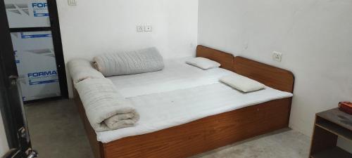 1 dormitorio con cama de madera en una habitación en Lumbini Village Garden Lodge en Lumbini