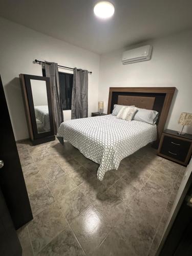 a bedroom with a bed and a large mirror at Sunrise Apartments in Rosarito