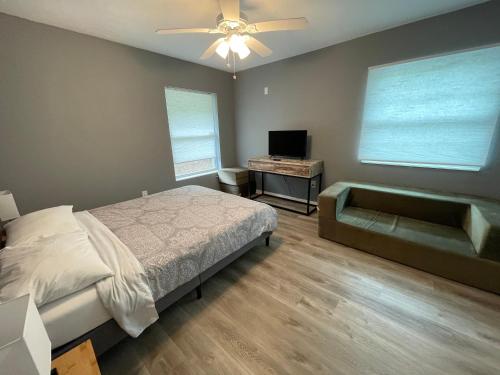 um quarto com uma cama, um sofá e uma ventoinha de tecto em Downtown Sarasota House by Siesta Key and Pinecraft em Sarasota