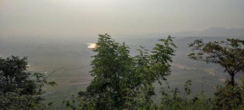 a view of a valley from behind some trees at Gitanjali Forest Retreat in Bāghmundi