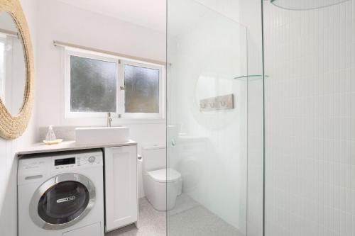 a bathroom with a washing machine and a shower at Bungalow 127 at Avalon pde, 800m walk to beach in Avalon