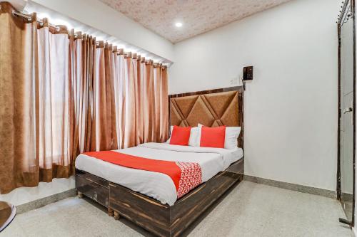 a bedroom with a bed with red pillows at Hotel O Sun View in Ludhiana
