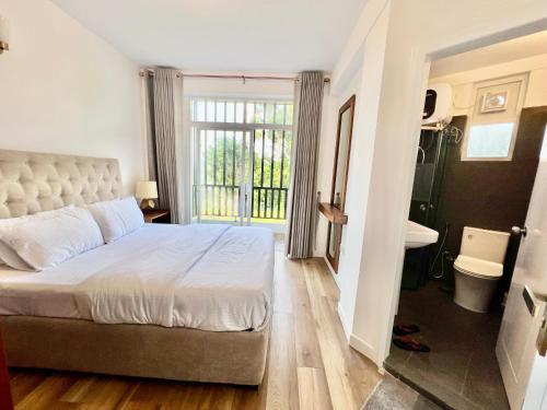 a bedroom with a large bed and a bathroom at Lake View Residencies in Nuwara Eliya