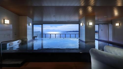 a large swimming pool with a view of the ocean at Ako Onsen Shokichi in Ako