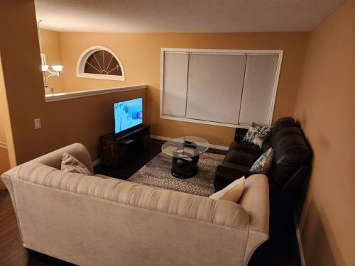 sala de estar con sofá y TV en Beautiful updated home centrally located, close to General Hospital en Regina