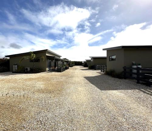 a house with a gravel driveway next to a building at Country Retreats on Ranzau 7 in Hope