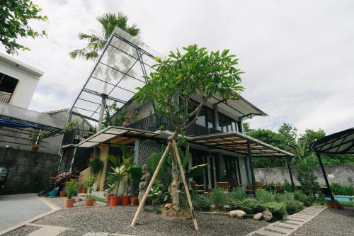 a house with a tree in front of it at The Jungle Hostel Canggu in Canggu
