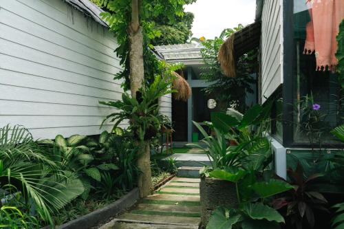 a garden entrance to a house with plants at The Jungle Hostel Canggu in Canggu
