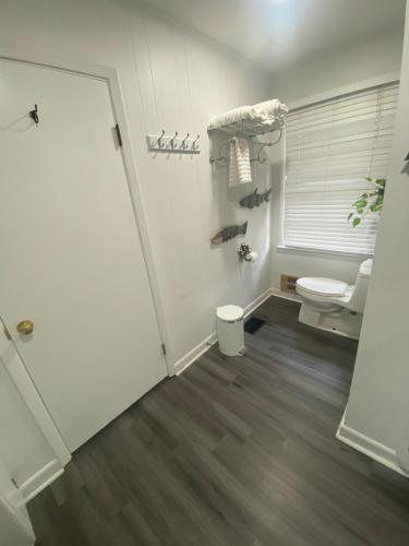 bagno bianco con servizi igienici e porta di Elias Lake House a Gainesville