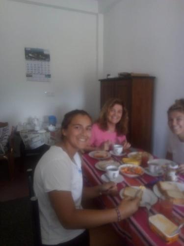 a group of people sitting at a table eating food at Frosty Heaven Guest House in Nuwara Eliya
