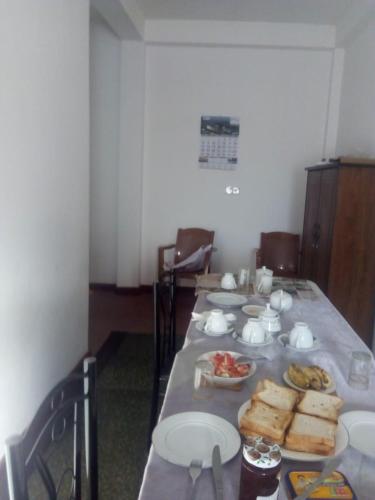 a long table with plates of food on it at Frosty Heaven Guest House in Nuwara Eliya